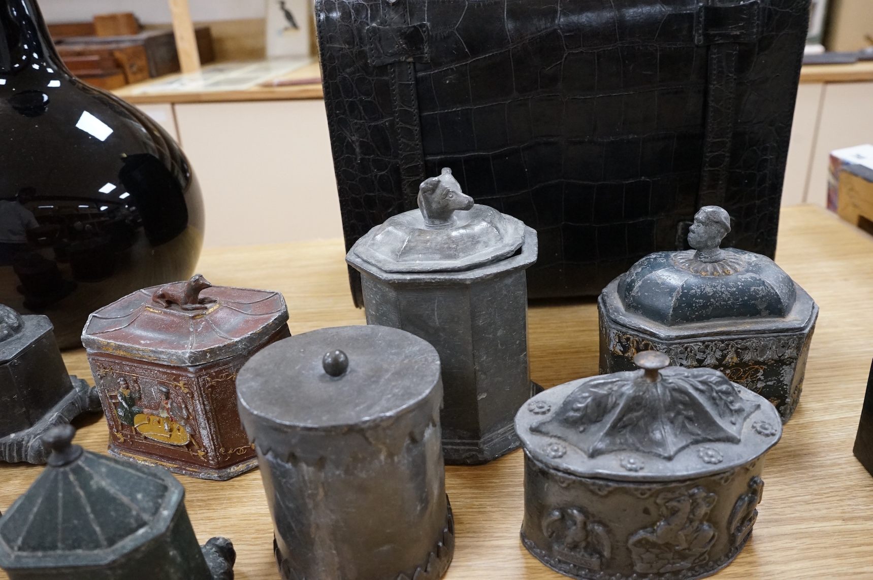 A collection of ten early 19th century lead tobacco boxes, to include an octagonal example, decorated in relief with the remains of red and gilt paint, largest 13cm wide